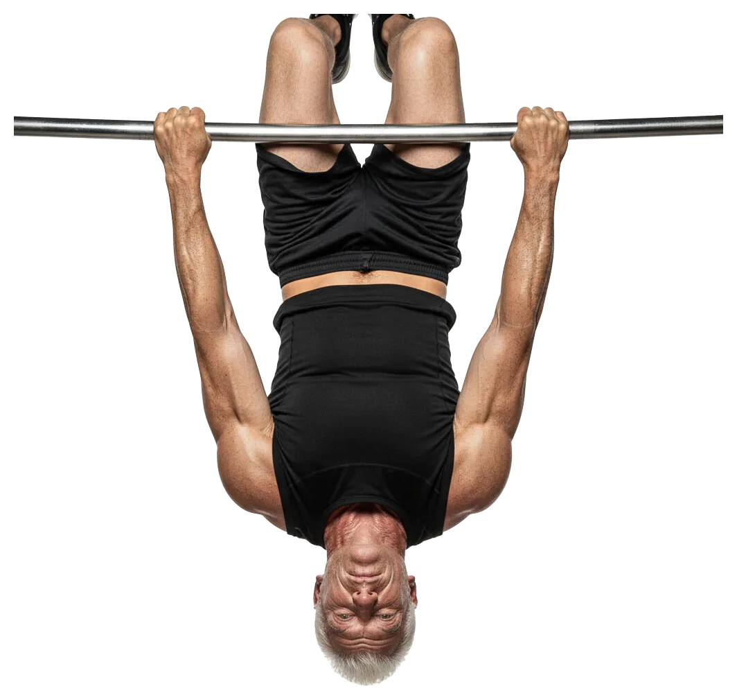 A muscular older man is hanging upside down from a horizontal bar, showcasing his strength. He is wearing a black sleeveless shirt and shorts, with a determined look on his face, emphasizing fitness.